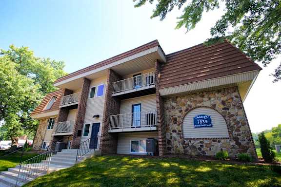 A stone and wood building with a balcony and a blue sign with the number 7839.