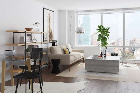 A modern living room with a large window overlooking a cityscape at The Maximilian Apartments, Long Island City, New York