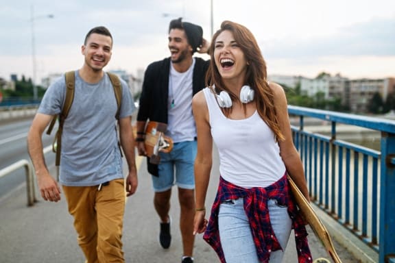a group of young people walking down a bridge laughing