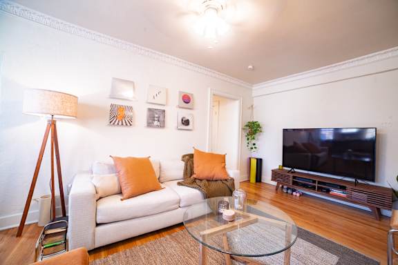 A living room with a white couch and a television.