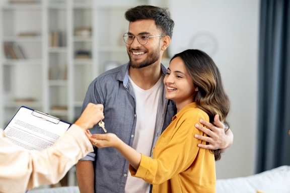 A person is handing over a key to another person.