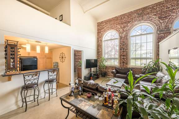 A living room with a brick wall and a large window.