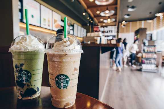 Two Starbucks drinks with green straws on a table. at Las Brisas Apartment Homes, Round Rock, TX