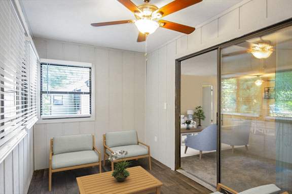 a small living room with a ceiling fan and a sliding glass door at Edgemont Apartments, PRG Real Estate, Greenville, 29615