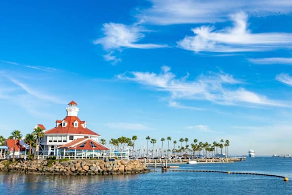 A lighthouse stands on a pier overlooking a calm sea.