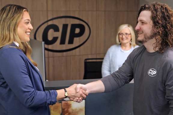 Two people shaking hands in front of a CIP logo.