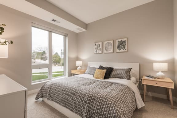 a bedroom with a bed and a large window