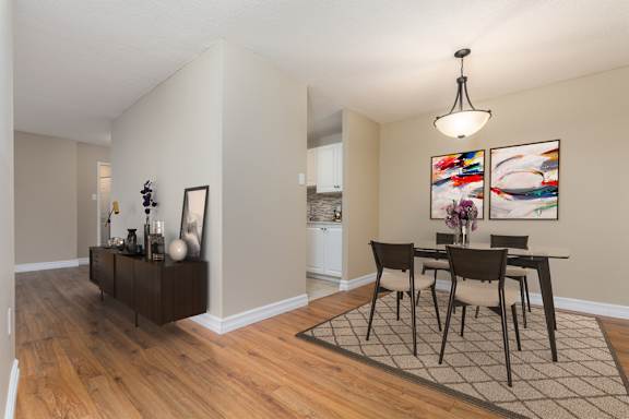 A modern kitchen with a stainless steel refrigerator and wooden flooring.