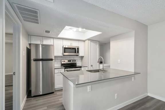 A modern kitchen with stainless steel appliances and a central island.