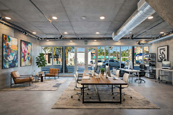 A modern office live/work space with a large table and chairs at Fusion Hollywood Apartments.