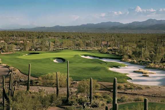A golf course with a green and a water hazard.