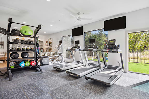 A gym with treadmills, weights, and exercise equipment.