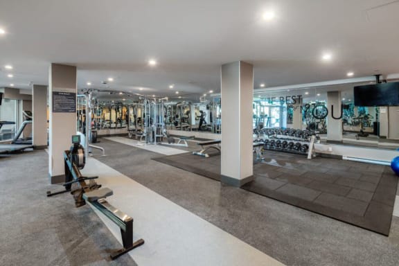 a gym with treadmills and other exercise equipment in a building with