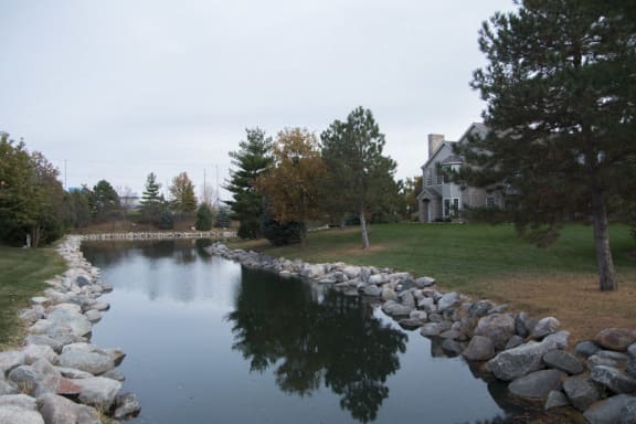 Private pond lined with trees and landscaping at Stone Ridge Estates