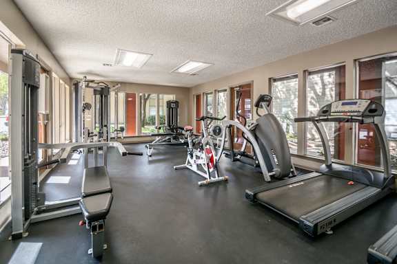 Fitness center with treadmills and weight training machines at The Colony Apartments, Universal City, Texas