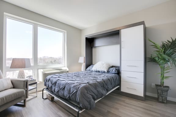 Open murphy bed in bedroom with large window