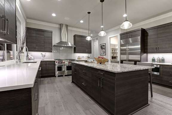 A modern kitchen with dark wood cabinets and a central island.