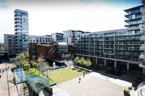 a view of a city courtyard with buildings and trees