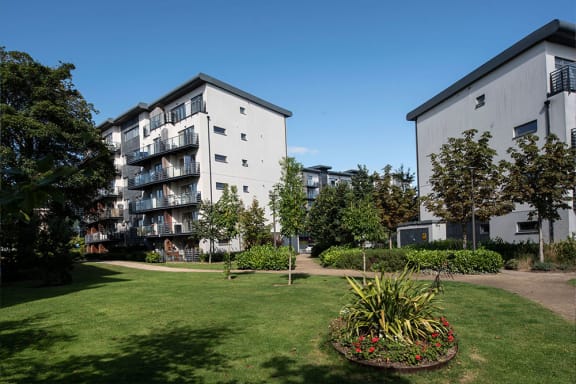 the courtyard of an apartment building with grass and trees