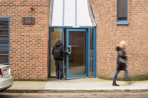 a man is standing in front of a door to a building