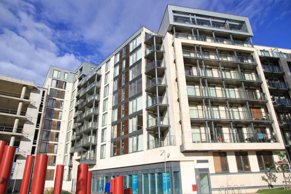 a large apartment building with many balconies and a blue sky