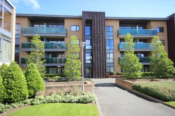 a view of an apartment building with a pathway and trees
