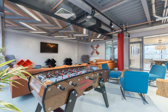 a lounge area with chairs and tables and a large window