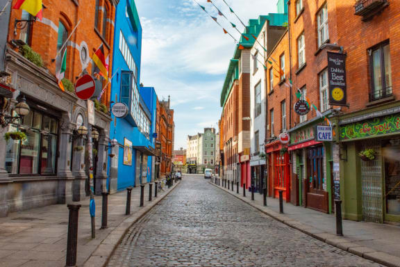 a cobblestone street in a city with colorful buildings