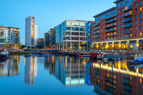the city of docklands at night with boats in the water