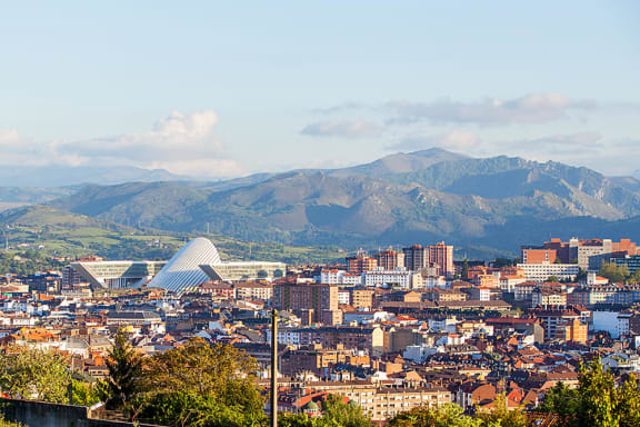 a cityscape of a city with mountains in the background