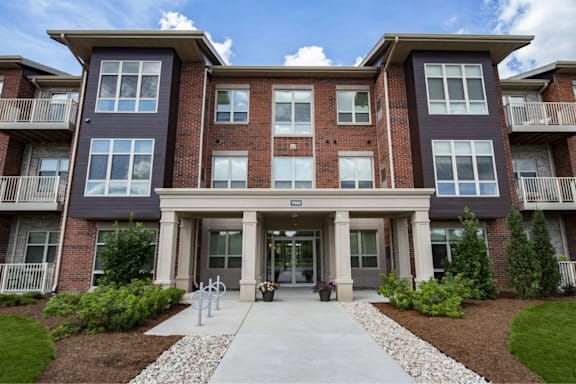 an apartment building with a sidewalk in front of it