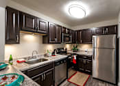 Thumbnail 6 of 17 - Renovated Kitchen with Dark Sable Cabinetry and  Stainless Steel Appliances at River Mews Apartments and Townhomes in Hampton Roads, VA