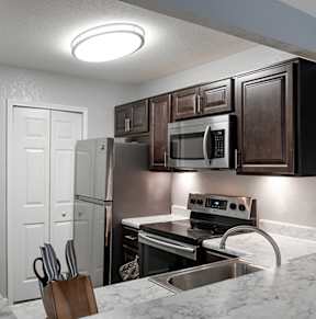 A kitchen with a white fridge and a stainless steel sink.