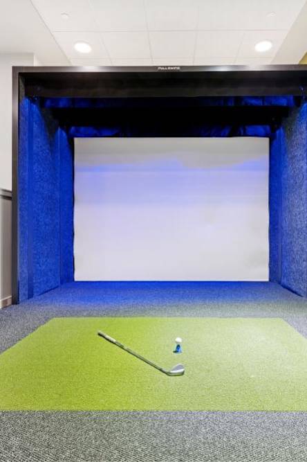 A room with a blue curtain and a green mat on the floor.