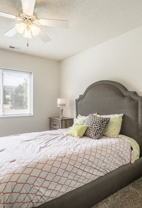 Bedroom with ceiling fan and natural light at Northridge Heights in north Lincoln