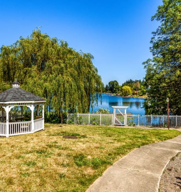 a gazebo in a park next to a lake