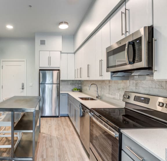a kitchen with a large island and a living room with a couch and a tv