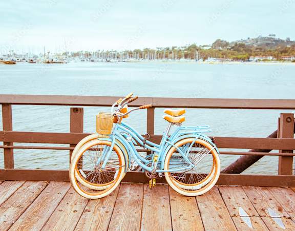 A blue bicycle is parked on a wooden dock by the water.