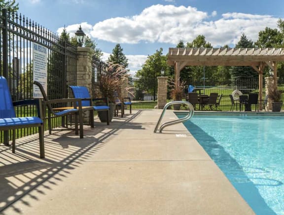 Pergola with swimming pool and chairs at Stone Creek Villas townhomes in west Omaha NE 68116