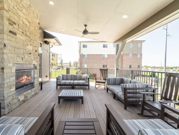a covered patio with furniture and a fireplace