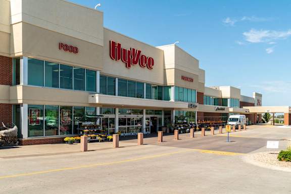 A Hy-Vee store with a parking lot in front.