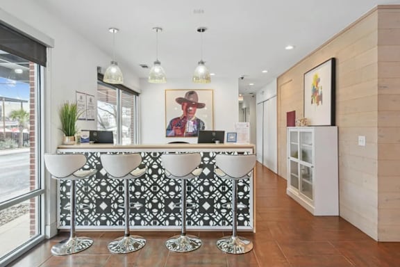 Reception desk with decorative tile front and pendant lighting at Lofts on Main Apartments, San Antonio, 78212
