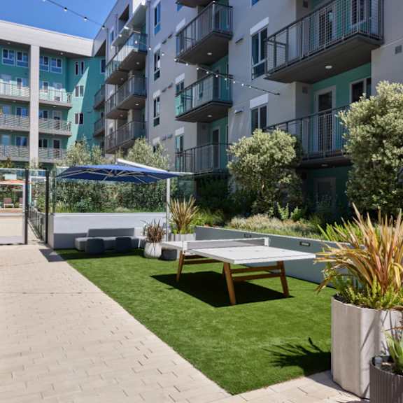 Anton Pacific patio with a table and chairs in front of an apartment building in Santa Cruz