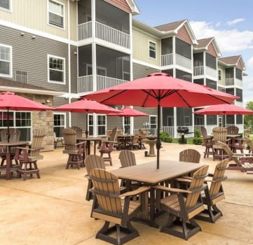 an outdoor patio with tables and umbrellas at an apartment complex