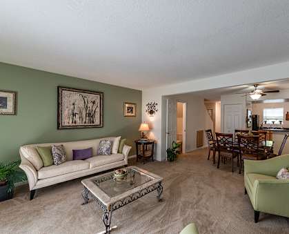A living room with a couch, chairs, and a coffee table.
