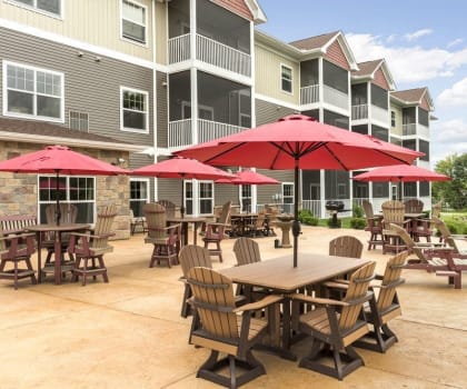 an outdoor patio with tables and umbrellas at an apartment complex
