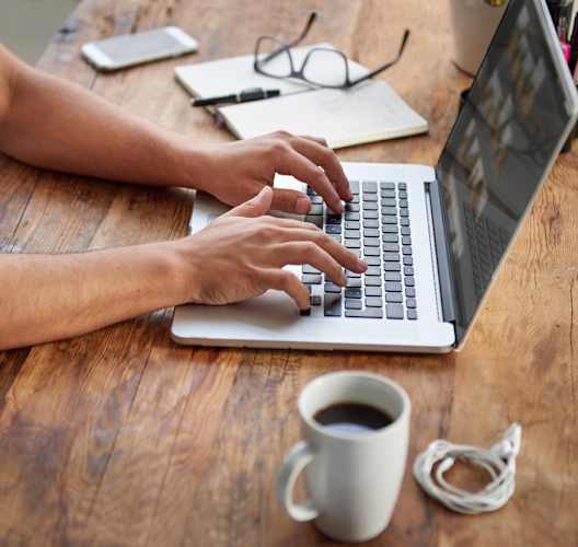 a person using a laptop to lease an apartment from a coffee shop