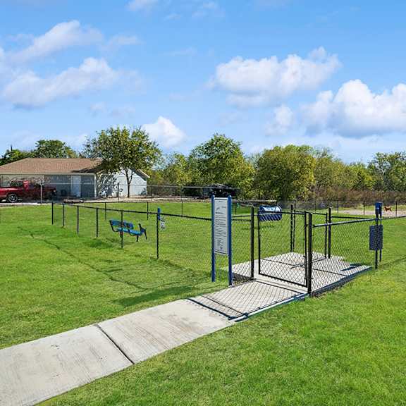 A playground with a blue umbrella and a green slide.