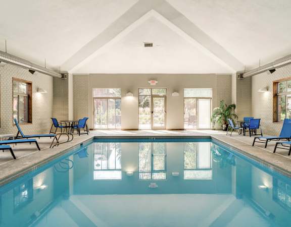 a swimming pool with blue chairs and chairs around it