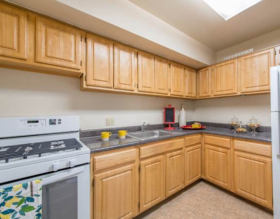 A kitchen with wooden cabinets and a white refrigerator.